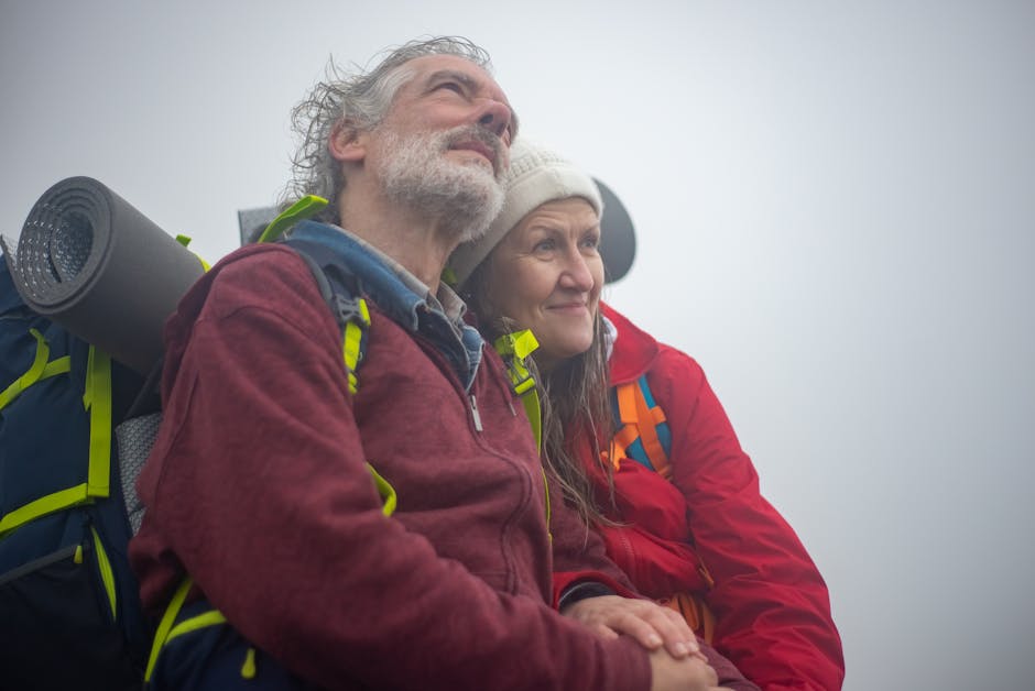 Senior couple enjoying a winter hike in the misty mountains. Embracing the quiet outdoors.