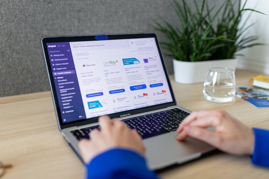 Close-up of hands on a laptop browsing an e-commerce site in a modern office.