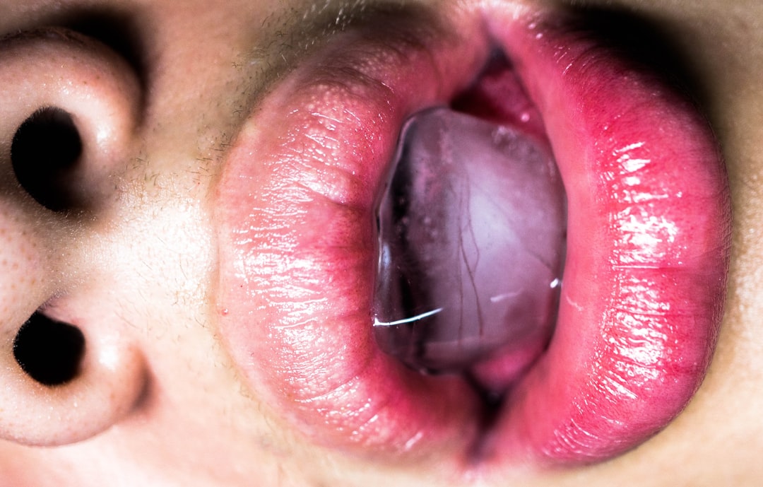 A close up of a person's tongue with a piece of food in the