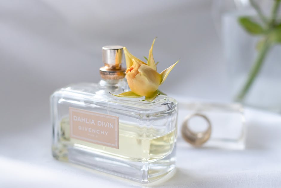 Close-up of a luxury perfume bottle with a yellow rose bud, showcasing elegance and fragrance style.