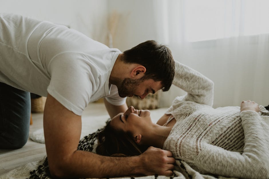 Young couple sharing a joyful and intimate moment together on the floor indoors.