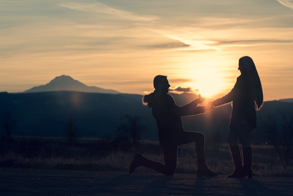 A romantic couple silhouetted at sunset with a proposal gesture against a mountain backdrop in Türkiye.